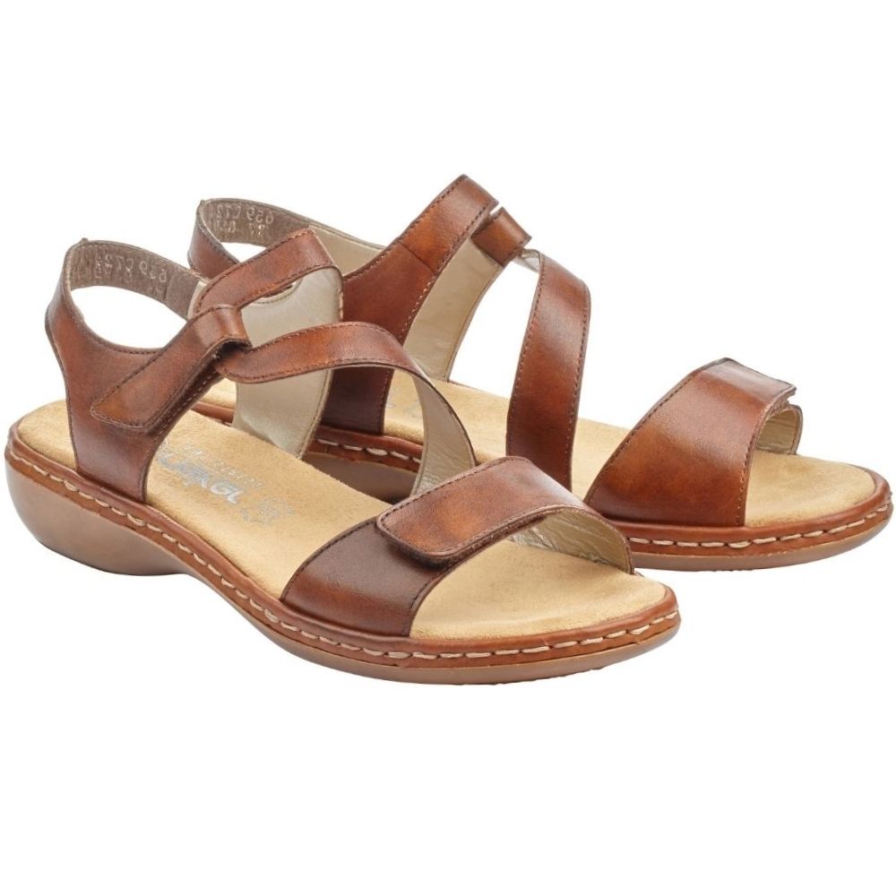 A pair of women's tan leather strappy sandals with low wedge heels, displayed on a clean white background.