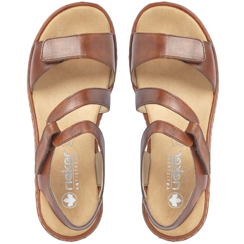 A pair of tan leather strappy sandals with tan footbeds, shown from a top-down view on a white background. The brand name 'Rieker' is visible on the insole.