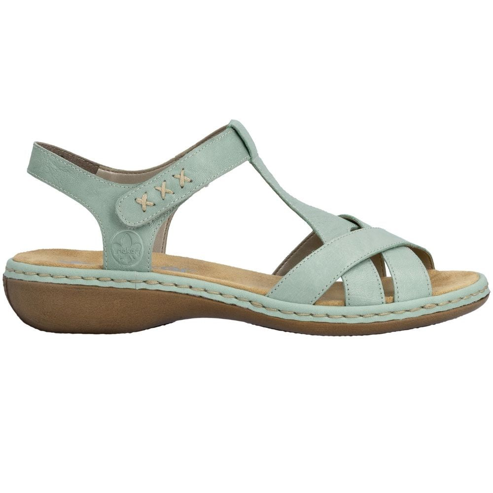 A single women's T-strap sandal in a light sage green color, featuring a brown wedge sole and a tan footbed, shown from a side profile on a white background.