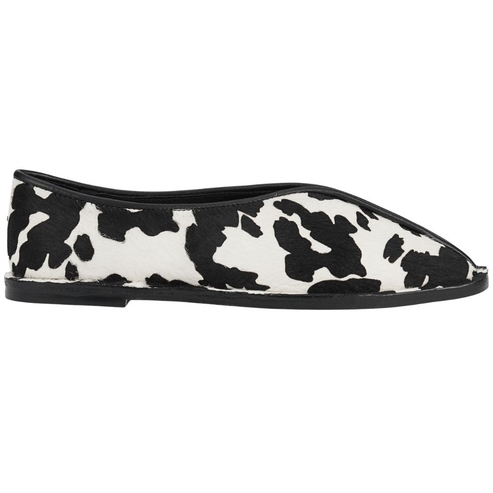 Black and white cow print flat shoe on a white background
