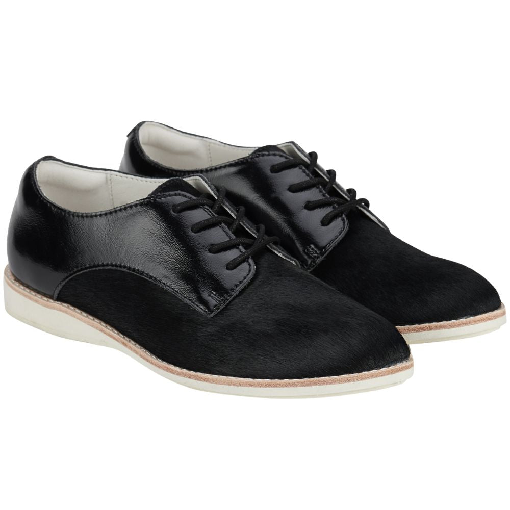 Pair of black patent and pony leather shoes with black laces on a white background