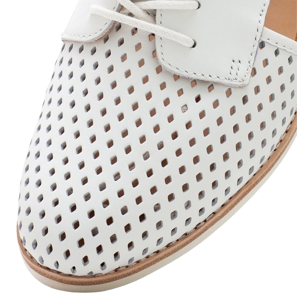 White perforated leather shoe with white laces and a tan outsole, shown in a close-up studio shot on a white background.
