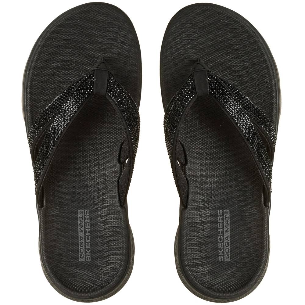 A pair of Skechers flip-flop sandals in black, featuring textured insoles and glittery rhinestone-embellished straps, shown from a top-down view on a white background.