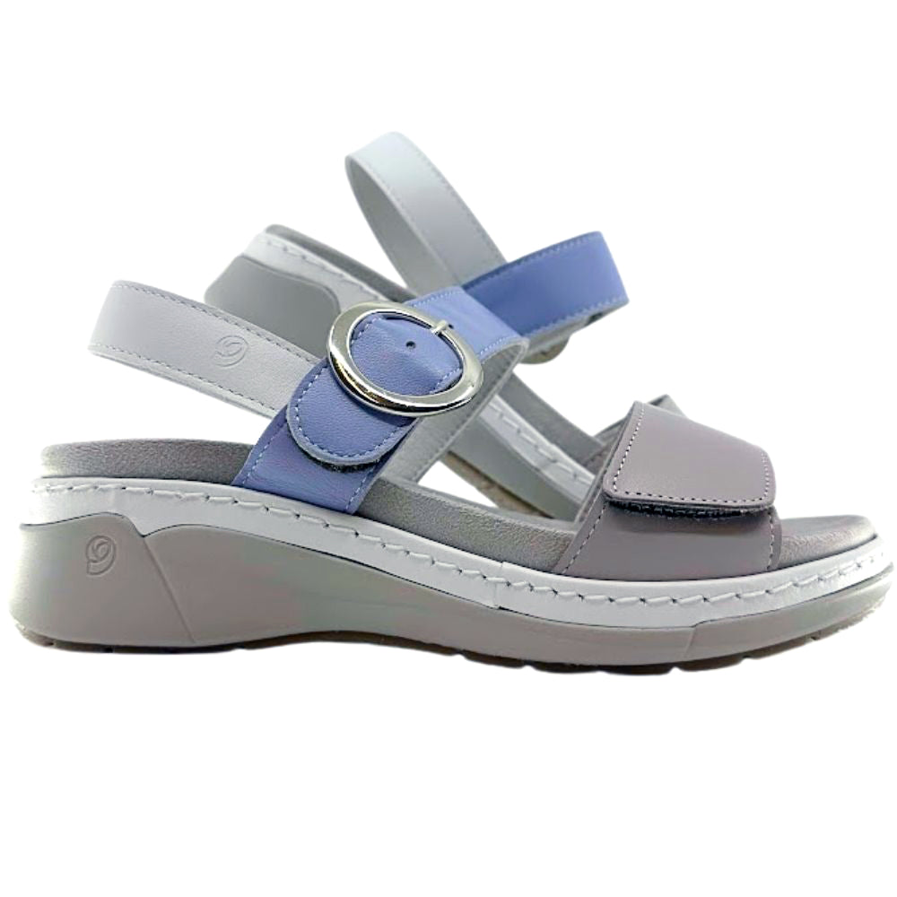 A women's wedge sandal in light gray and periwinkle blue, featuring a wide adjustable strap with a silver buckle, a front strap with a hook-and-loop closure, and a thick cushioned wedge sole.