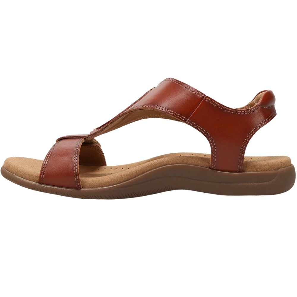 A cognac leather T-strap sandal with a contoured brown sole, shown in a side profile view against a plain white background.