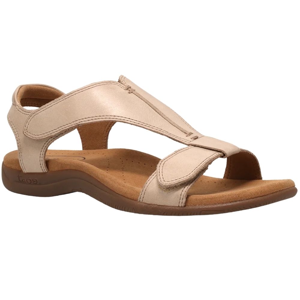 A single women's flat sandal in a light beige leather finish with a brown footbed and sole, shown from a side profile on a white background.