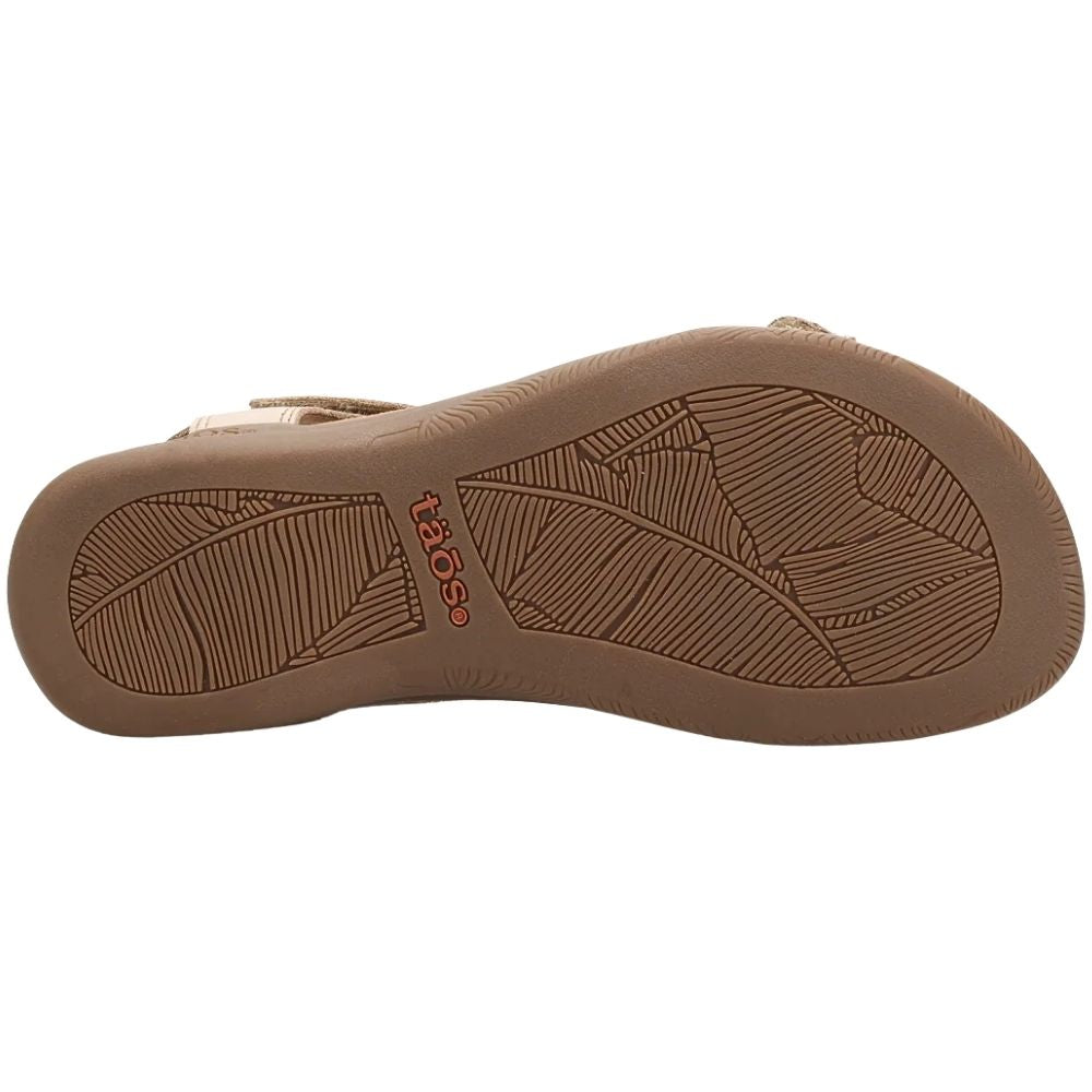 The brown rubber outsole of a sandal, featuring a textured leaf-like tread pattern and the red 'taos' brand logo, shown against a plain white background.