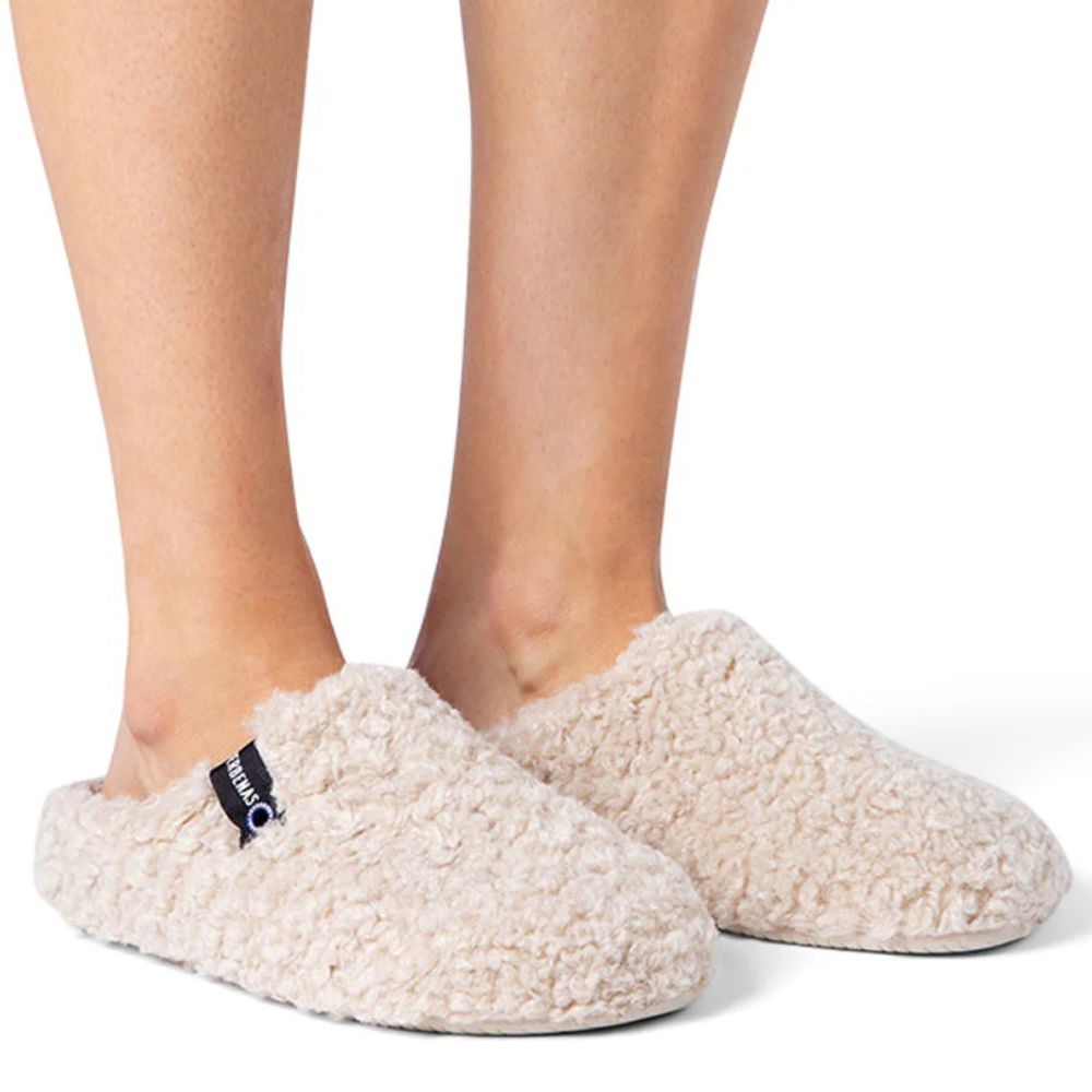 Beige slippers worn by a person on a white background