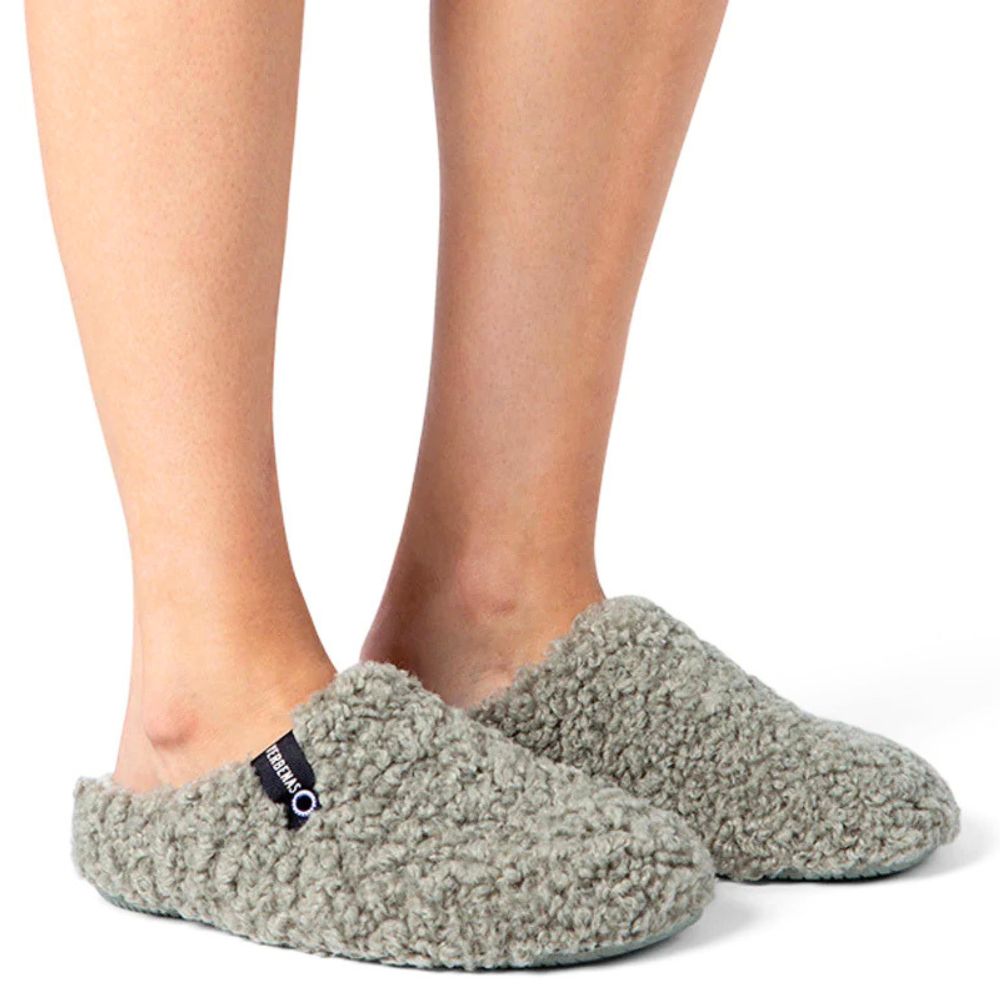 Green textured slippers worn by a person on a white background