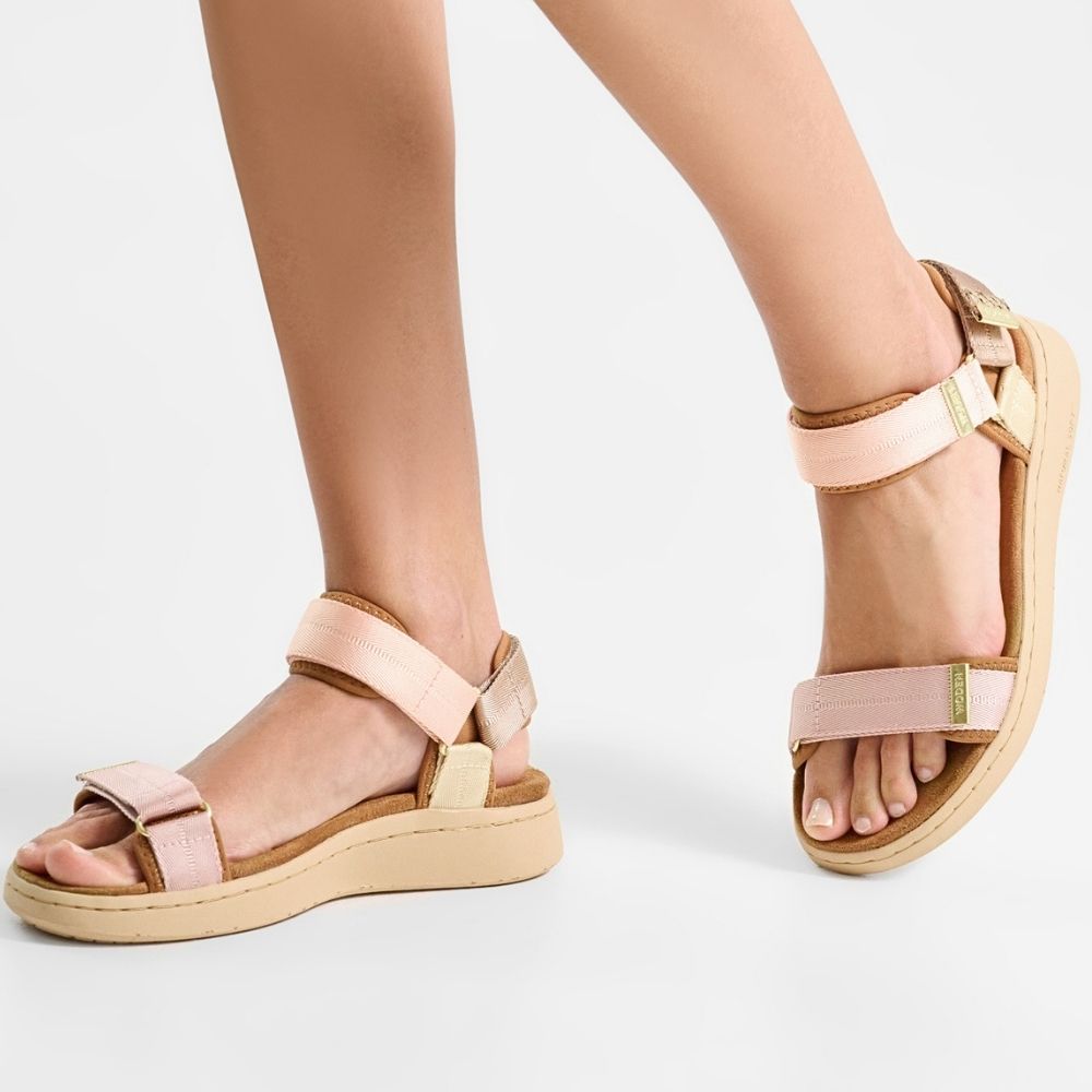 A pair of women's platform sandals in light blush pink and beige, shown on a model's feet against a clean white background.