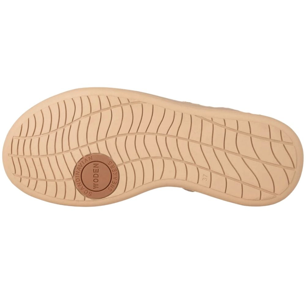 The outsole of a shoe in a light tan color, featuring a wavy tread pattern and a circular brown brand patch in the center that reads 'WODEN'.