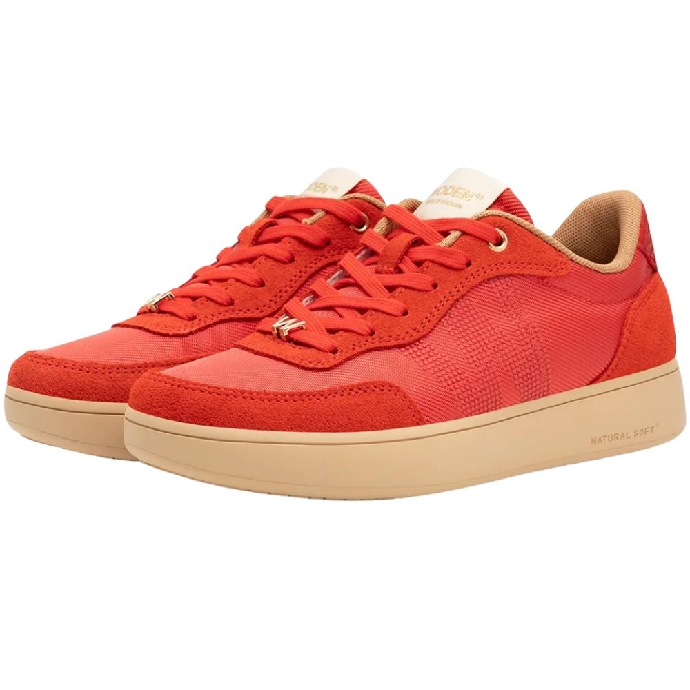 A pair of low-top sneakers in a vibrant red-orange colorway, featuring a mix of textured mesh and suede panels, matching red laces, and beige soles. The brand 'WODEN' is subtly visible on the tongue and side.