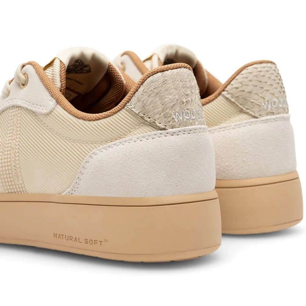 A pair of low-top platform sneakers in beige and cream tones, featuring textured mesh panels, smooth overlays, a fish leather patterned heel tab, and a thick beige platform sole with 'NATURAL SOFT' printed on the side.