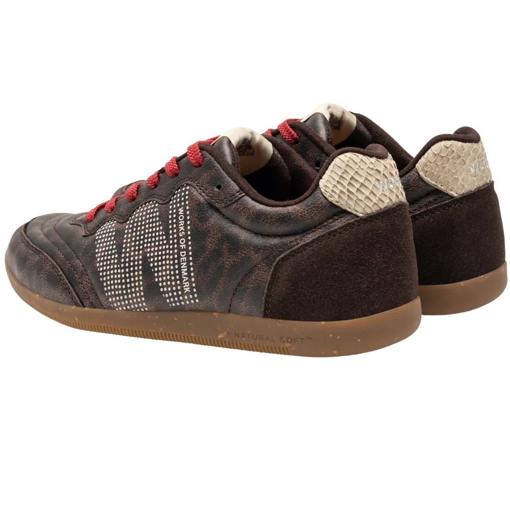 The back view of a pair of low-top sneakers by Woden featuring dark brown textured animal print uppers, red laces, and brown gum rubber soles.