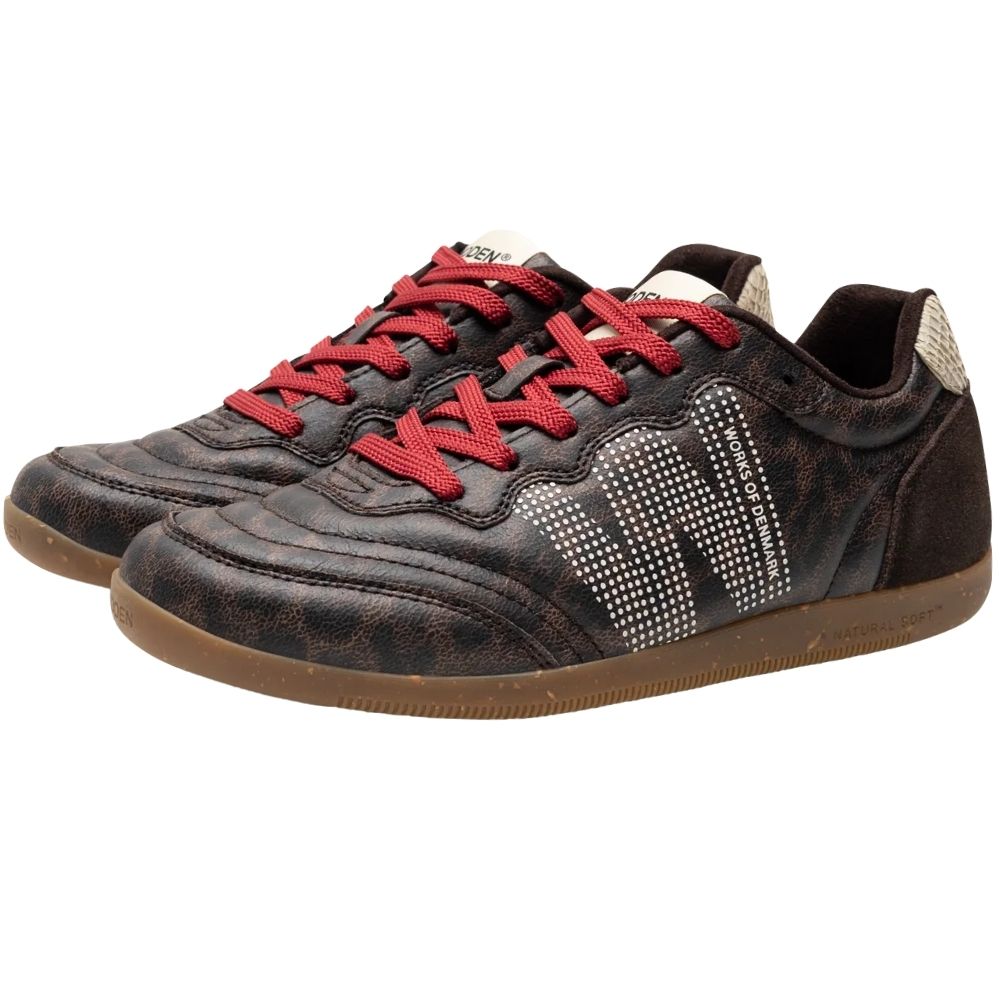A pair of low-top sneakers by Woden featuring dark brown textured animal print uppers, red laces, and brown gum rubber soles.
