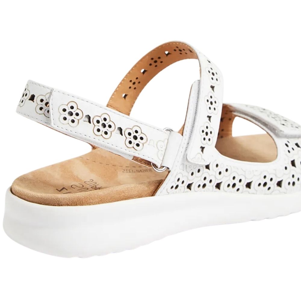 White platform sandal with floral cutout details on the straps, featuring a tan insole and white sole, shown on a white background.