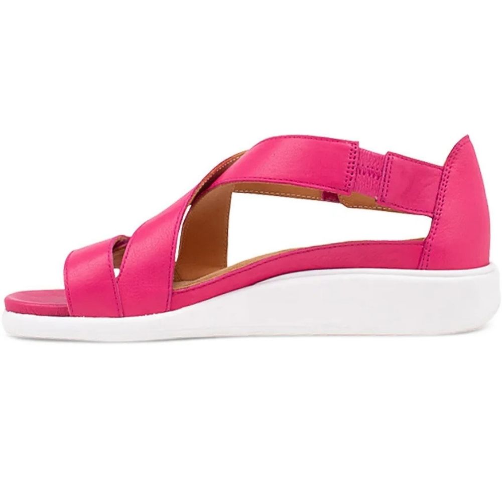 A bright pink open-toe wedge sandal with crisscrossing straps and a white platform sole, shown in a side profile on a white background.