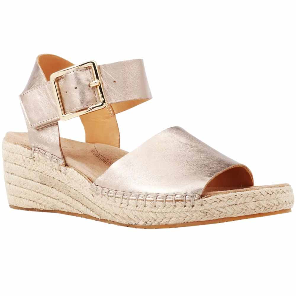 A metallic champagne-gold espadrille wedge sandal with an ankle strap and gold buckle, shown from a side profile on a white background.